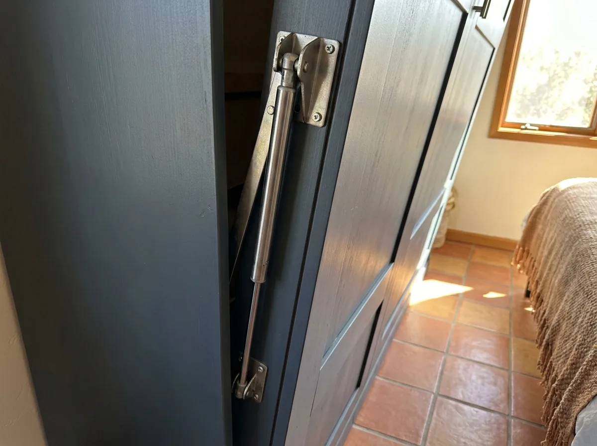 Steel gas piston lift mechanism on the door of a wall bed cabinet